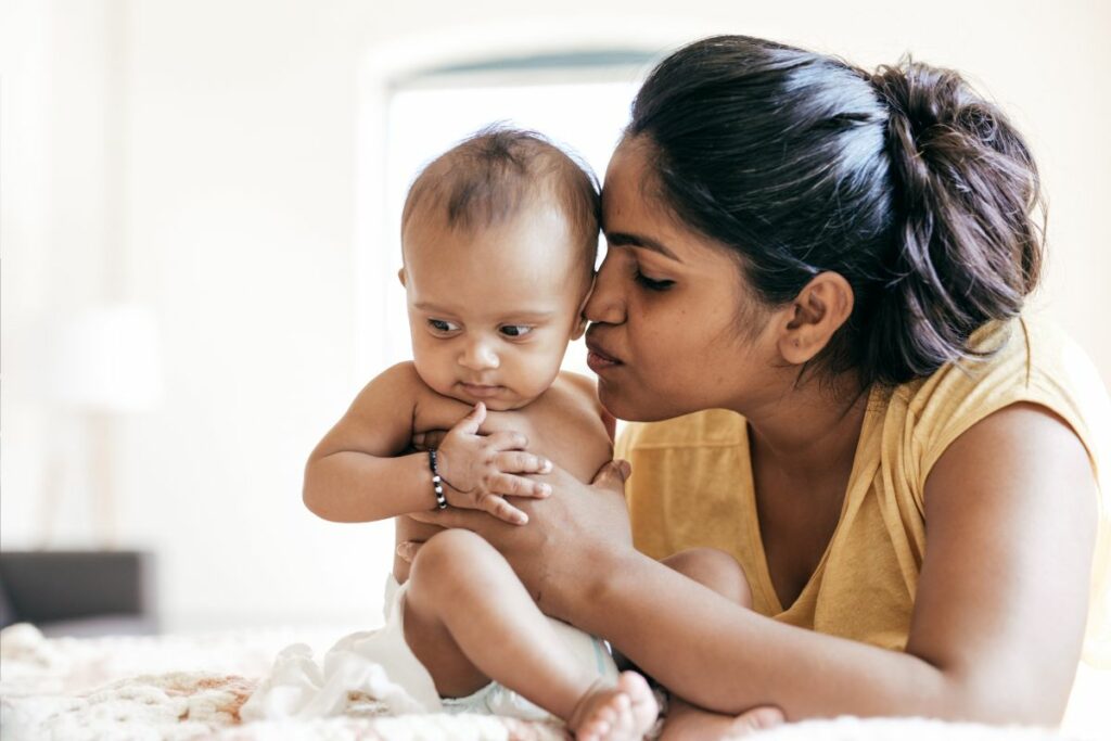 Indian mother kissing baby