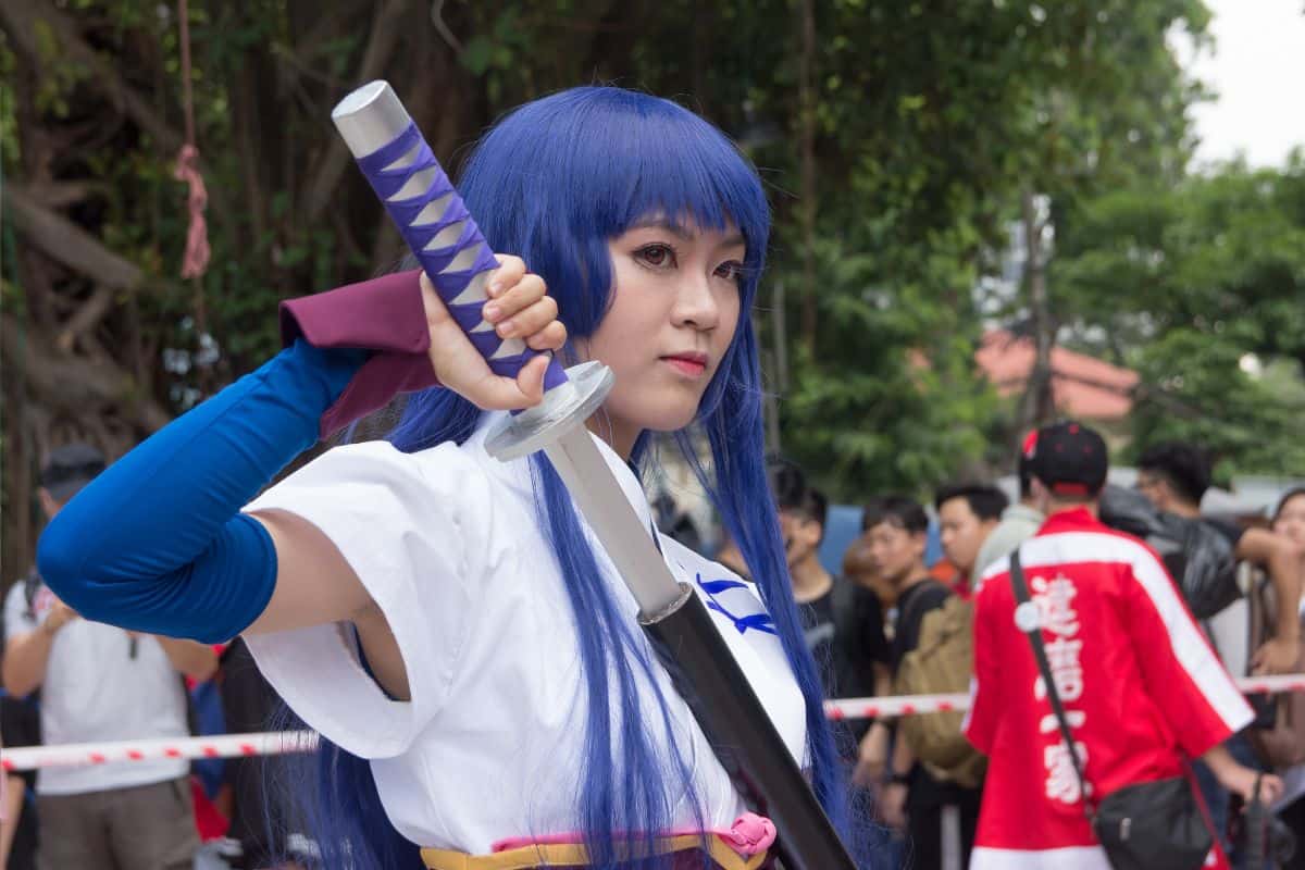 Anime girl character with blue hair and sword.