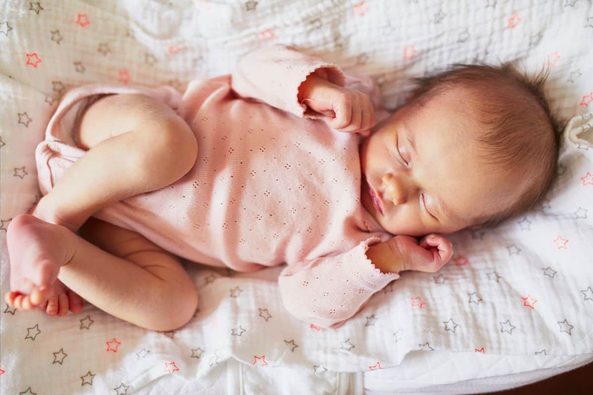 Top view of baby in pink onesie sleeping.