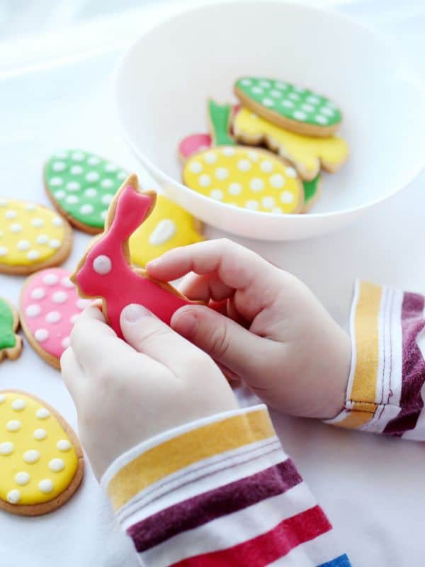 Child decorating Easter bunny cookies at indoor Easter baking activity